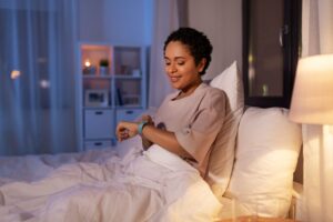 Personne au réveil consultant les données de son sommeil sur une montre connectée.
